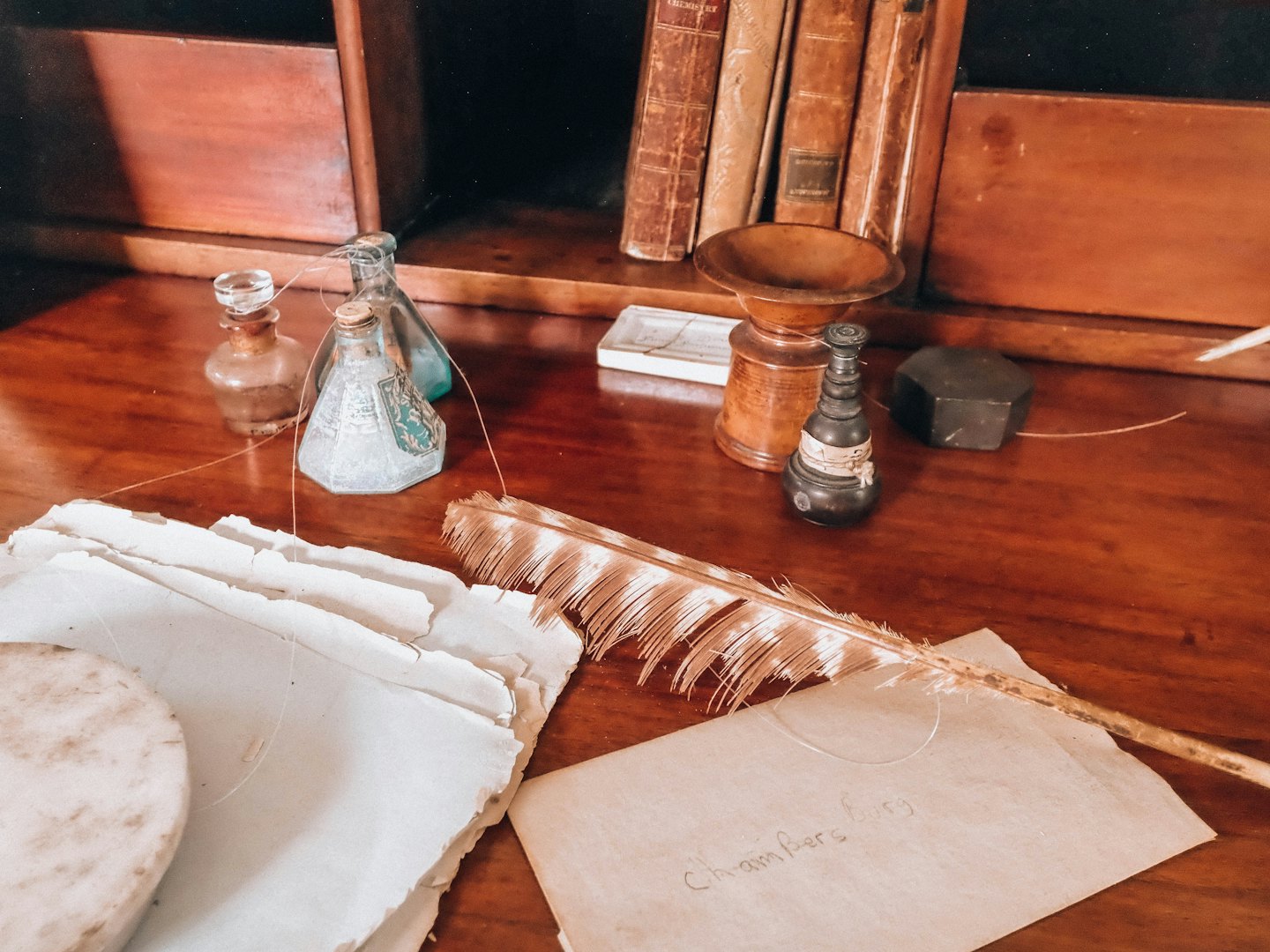 Una penna d'oca e carta antica su una scrivania di legno.